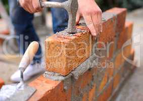 Laying the foundation one brick at a time. Shot of a master bricklayer at work.
