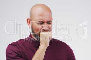 Bronchitis is not the best. Studio shot of a handsome young man coughing against a grey background.