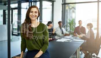 She the top dog at her company. Portrait of a businesswoman in a boardroom with her colleagues blurred out in the background.