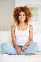 Theres something extremely exciting in owning a home. Shot of a young woman relaxing at home on the weekend.