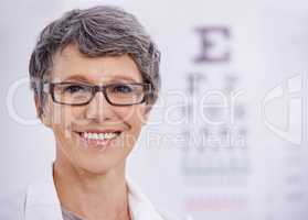 Read from the top down please. Portrait of a female optometrist standing beside an eye test poster.