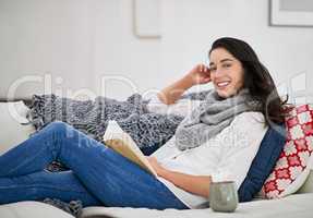 Theres no friends as loyal as a friend. Shot of a young woman reading a book while sitting in the living room.