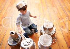 Kids rock. Shot of an adorable little boy drumming on pots and pans.