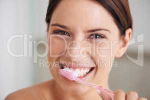 Shes all about dental hygiene. A gorgeous young brunette brushing her teeth in the morning.