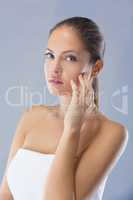 I like the way my skin feels. Head and shoulders studio shot of a beautiful young woman against a blue background.