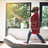 Slaying virtual dragons. Shot of a little boy in a kings costume playing with a vr headset on.