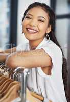 Today is going to be a great day in retail. Cropped portrait of young woman leaning on a clothing rail inside a store.