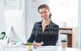 Dedication is the first requirement of success. Portrait of a young businesswoman working in an office.