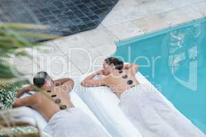 Synchronized harmony in luxury. High angle shot of a couple enjoying a hot stone massage.
