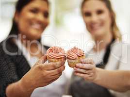 Well make you go cupcake crazy. Cropped shot of two bakers holding cupcakes.