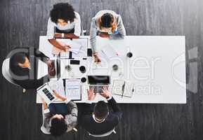 Gaining a lead together. High angle shot of a group of businesspeople having a meeting in an office.