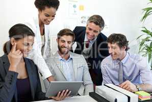 Making strategic decisions as a team. Shot of a group of businesspeople working together using a digital tablet.