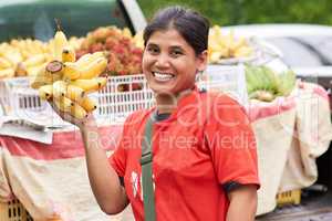 I only sell the freshest of produce. Portrait of a woman selling bananas at her market stall outside.