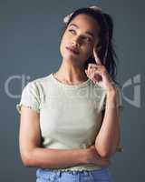 Im always thinking of ways to make a change. Studio shot of a young woman looking thoughtful against a grey background.