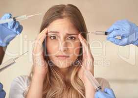 Is it really worth it to suffer for beauty. Portrait of an anxious young woman with needles pointed around at her face.