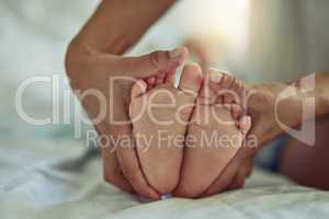 Theres nothing quite so sweet as tiny little baby feet. Shot of an unrecognizable mother and her childs feet at home.