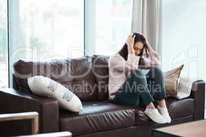 Its hard to fight the monster in your mind. Shot of a young woman experiencing mental anguish at home.