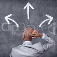 Make the right business choice. Conceptual shot of a businessman standing in front of a chalkboard with arrows on it.