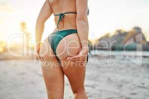 Good times and tan lines. Rearview shot of an unrecognizable woman at the beach.