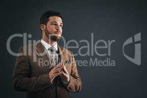 Leaders are only as strong as their passion and vision. Studio shot of handsome young businessman looking thoughtful against a dark background.