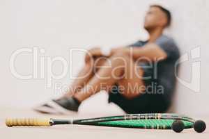 Just because youre beat doesnt mean youre beaten. Shot of a young man taking a break after playing a game of squash.