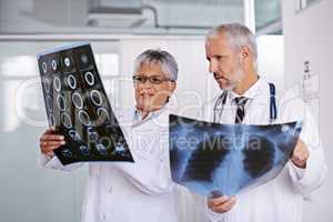 Identifying a diagnosis together. Cropped shot of two doctors viewing x-rays together.