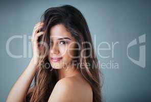 With great hair comes great responsibility. Studio portrait of a beautiful young woman posing against a gray background.