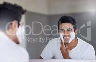 Sprucing up before a big date. Shot of a handsome young man shaving his facial hair in the bathroom.