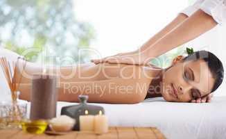 Pamper your senses. A young woman lying in a health sap surrounded by scented candles.