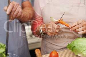 Weve become professionals at this already. Closeup shot focusing on the hands of two people preparing a meal together.