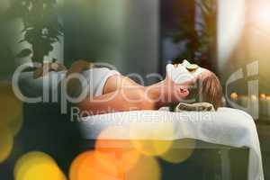 Relax, recharge, reflect, detox and beautify. Shot of a beautiful young woman lying on a massage table at the day spa.