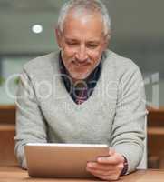 Going over his digital workflow. Shot of a mature businessman using a digital tablet while working in an office.