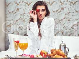 Enjoy a breakfast thatll give you a beauty boost. Shot of an attractive young woman enjoying a luxurious breakfast in her room.