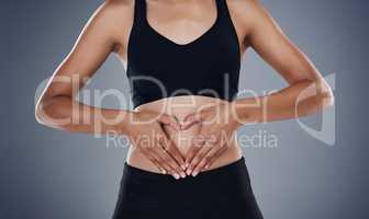 Shes in love with every curve on her body. Studio shot of a sporty young woman standing against a grey background.
