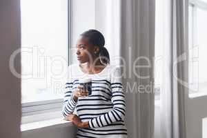 What are the neighbours up to now. A thoughtful young woman gazing out of a window on her coffee break.