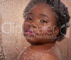 Cleanliness is next to goddessliness. Studio portrait of a beautiful young woman posing against a brown background surrounded by water droplets.
