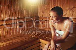 This is her bliss. Cropped shot of a young woman relaxing in the sauna at a spa.