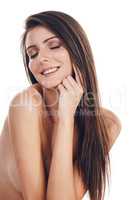 Shes a sight to behold. Studio shot of a gorgeous young woman smiling while standing nude against a white background.