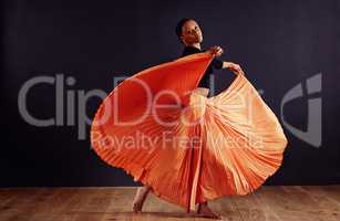 Exotic expression. Female contemporary dancer in a dramatic pose against dark background.