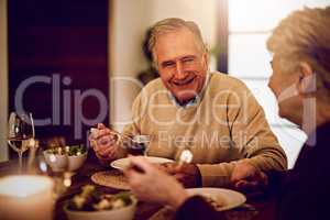After all these years, theyve never run out of conversation. Shot of an elderly couple enjoying a meal and wine together at home.