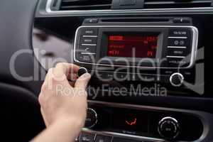 Tuning the stereo. Closeup shot of a driver tuning a car radio.