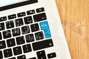 My post is all ready to go. High angle shot of a highlighted key of a bloggers laptop on a desk during the day.