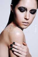 Sensual smokey eyes. Shot of a beautiful young woman wearing metallic-colored makeup and nail polish.