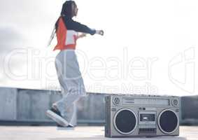 Move to the beat of your own drum. Shot of a young woman out on a rooftop with a boombox.