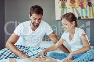 This game is going just as planned.... Shot of a man playing a board game with his little girl at home.