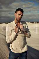 Getting away from it all. A ruggedly handsome young man enjoying the beach.