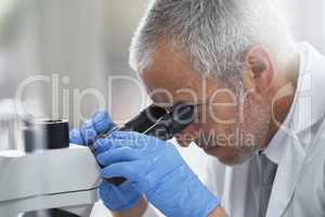Finding advances in the small things. Shot of a scientific researcher at work on a microscope in a lab.