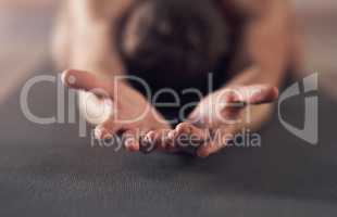 I surrender myself to the zen. Shot of an unrecognizable man stretching and practicing yoga indoors.