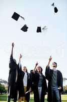 The rewards are all worth the effort. Shot of a group of students throwing their hats in the air on graduation day.