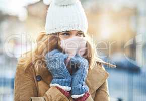 Its cold out here, I have to cover up. Shot of an attractive young woman enjoying being out in the snow.